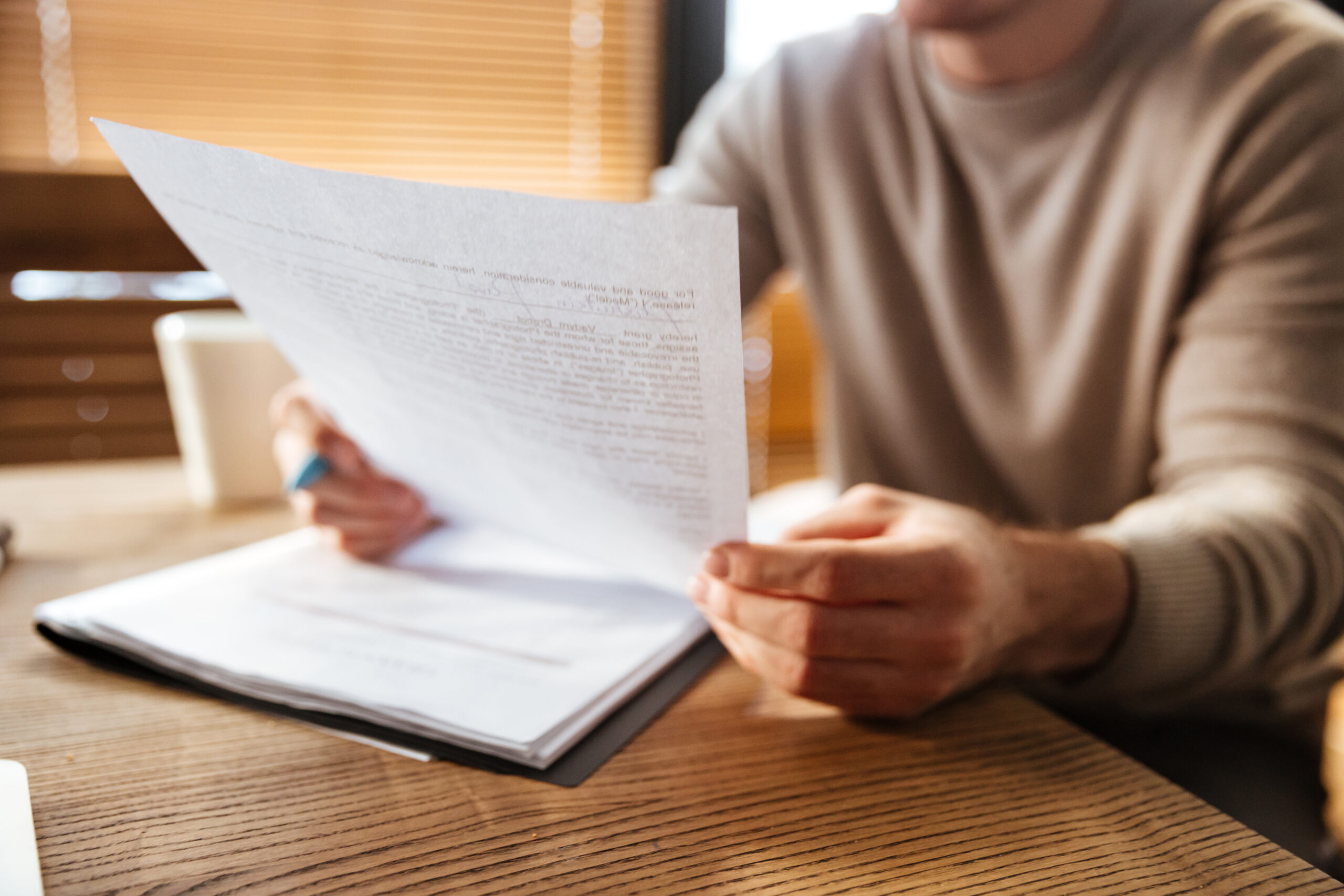 Male hands holding a printed document Male hands holding a printed document