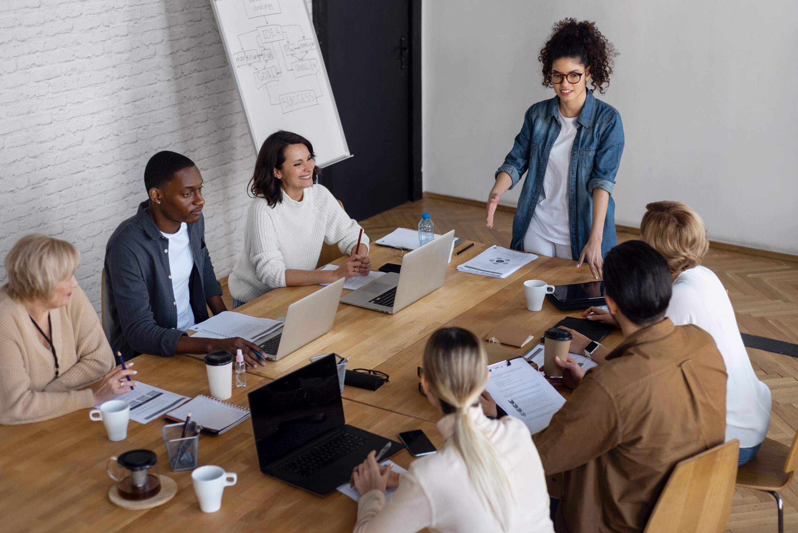 Group of professionals in a business meeting listening to a female leader Group of professionals in a business meeting listening to a female leader