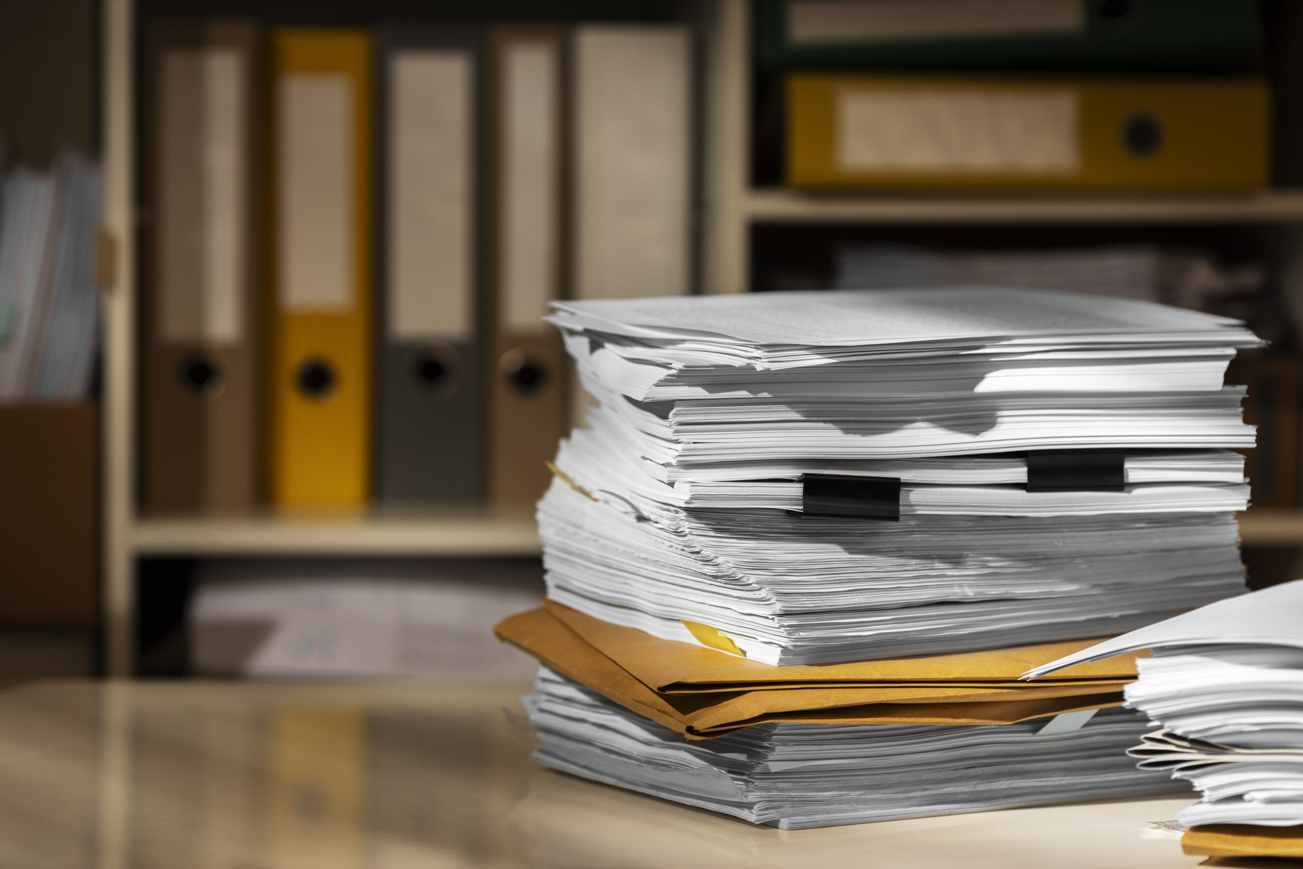 Intimidating stack of documents on a desk Intimidating stack of documents on a desk